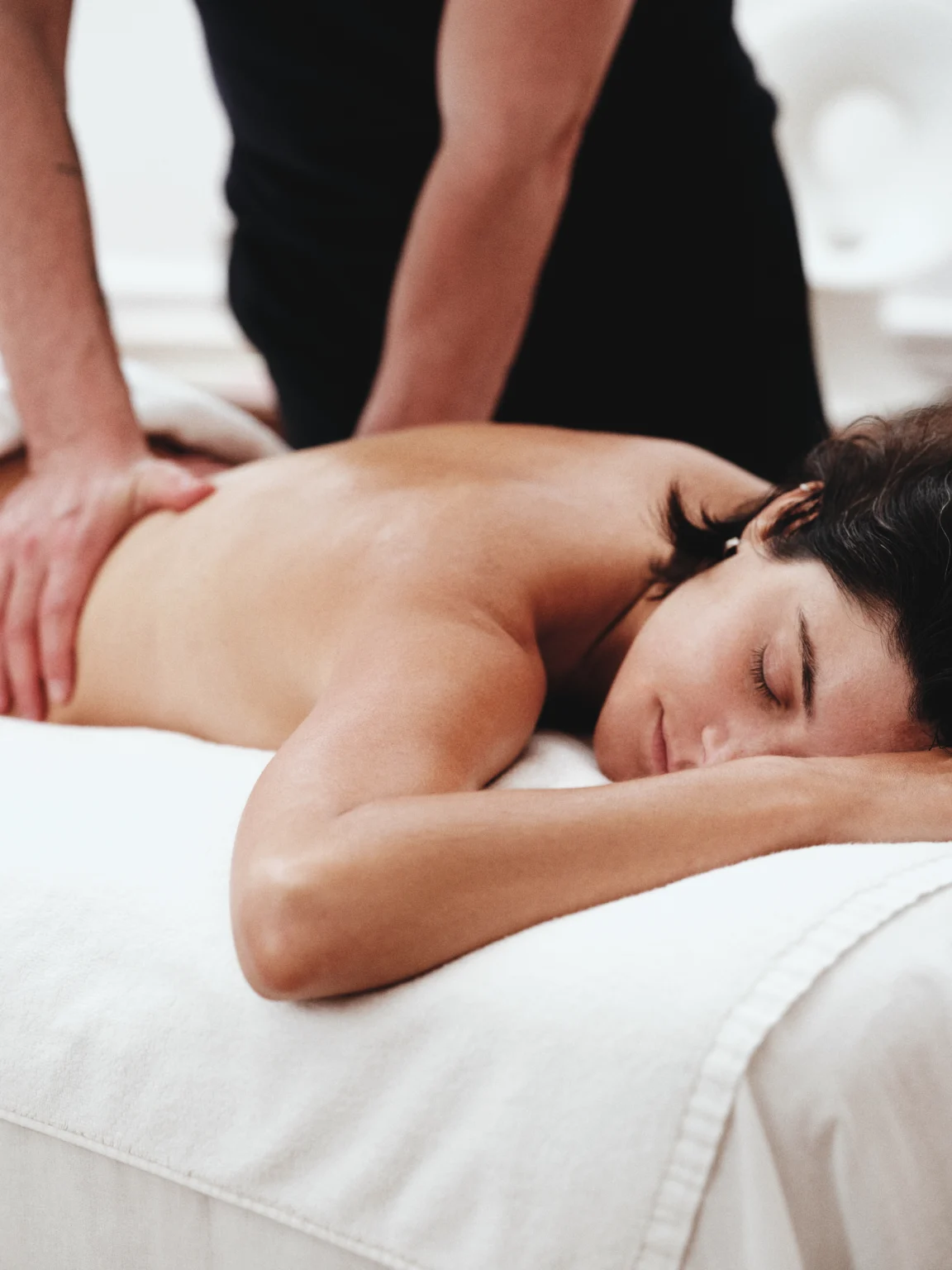 Femme allongée recevant un massage du dos.