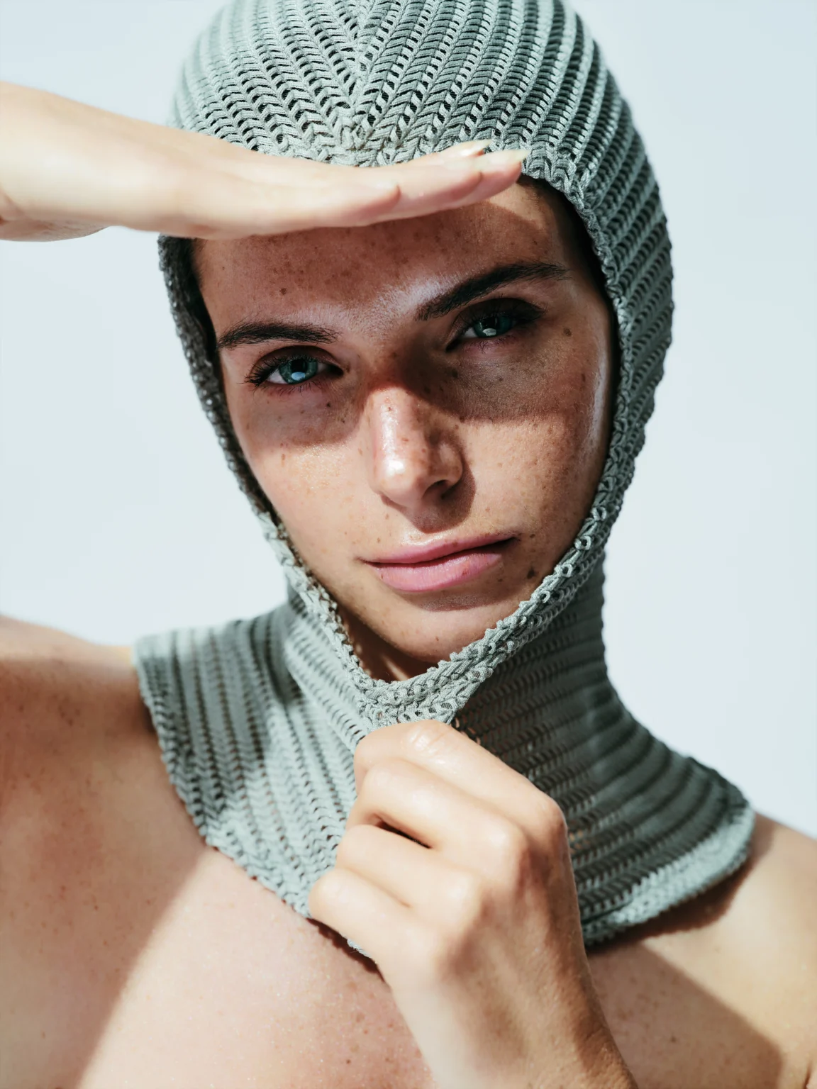 Portrait d’une femme portant une cagoule en maille verte.