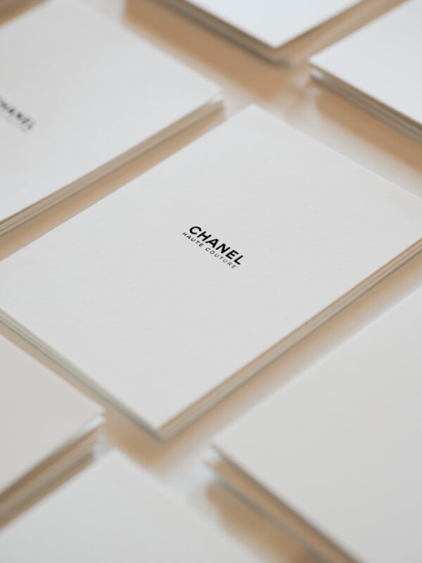 Boîtes blanches Chanel présentées dans une composition géométrique.