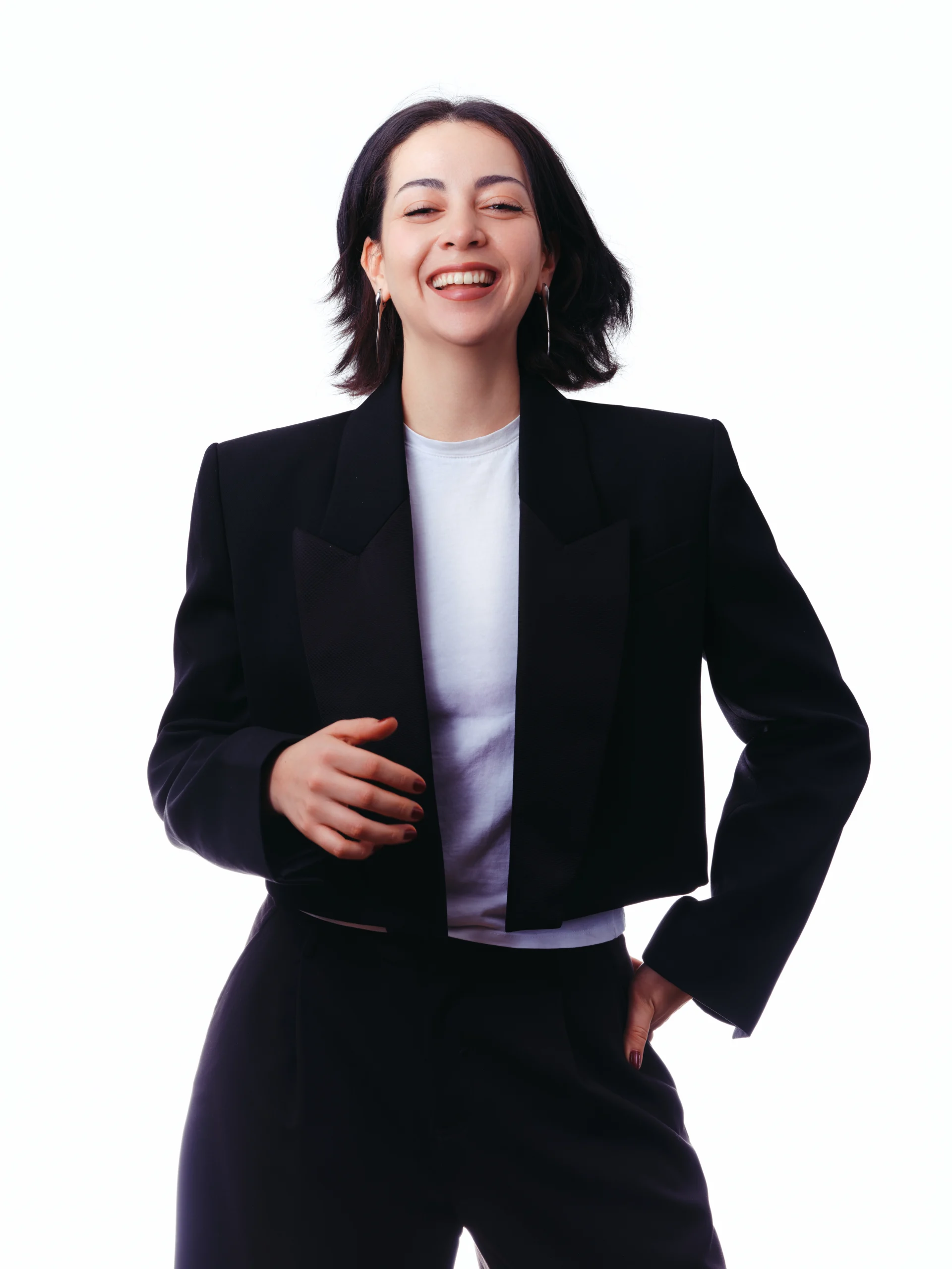 Portrait professionnel d’une femme souriante portant un tailleur noir.
