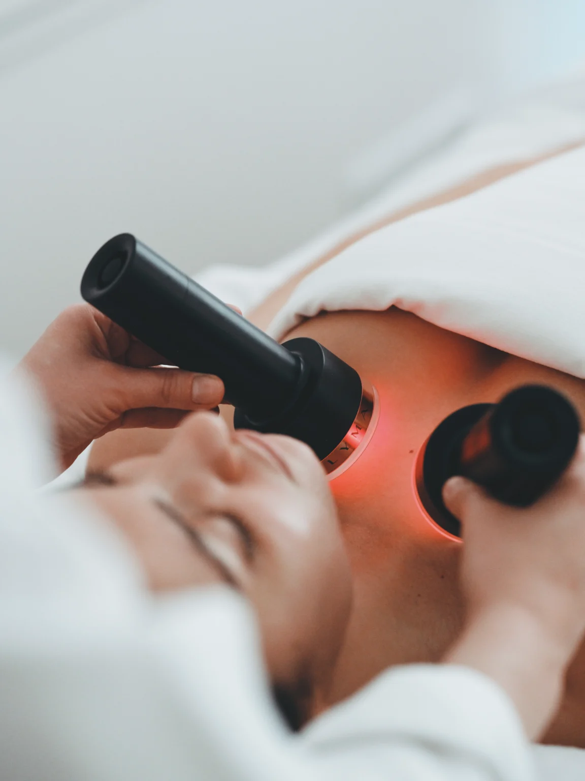 Appareil de soin utilisé sur le visage d’une cliente allongée.